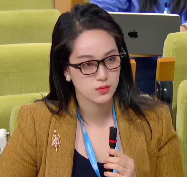 当全球镜头聚焦联合国记者会，中国记者陈莺迁从容起身提问时，她鼻梁上那副看似普通的