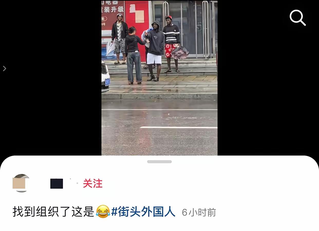 河南，下着雨。

路边4个外国人在避雨。

马路对面，一名黑衣女子看见了，扯着嗓