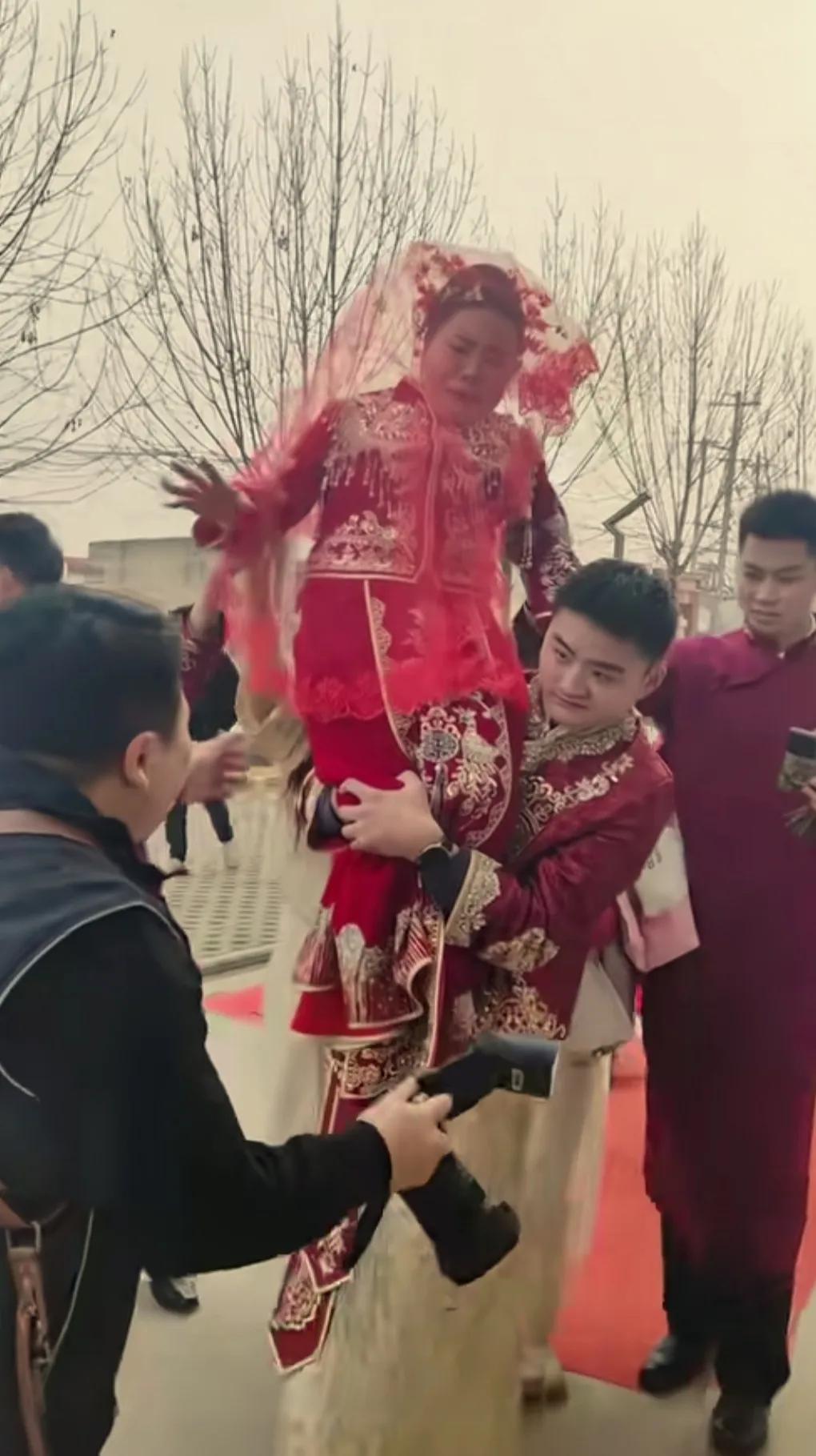 新郎年轻帅气，新娘长得成熟稳重。
新郎用尽全力的把新娘扛在肩膀上。
新娘害怕的花