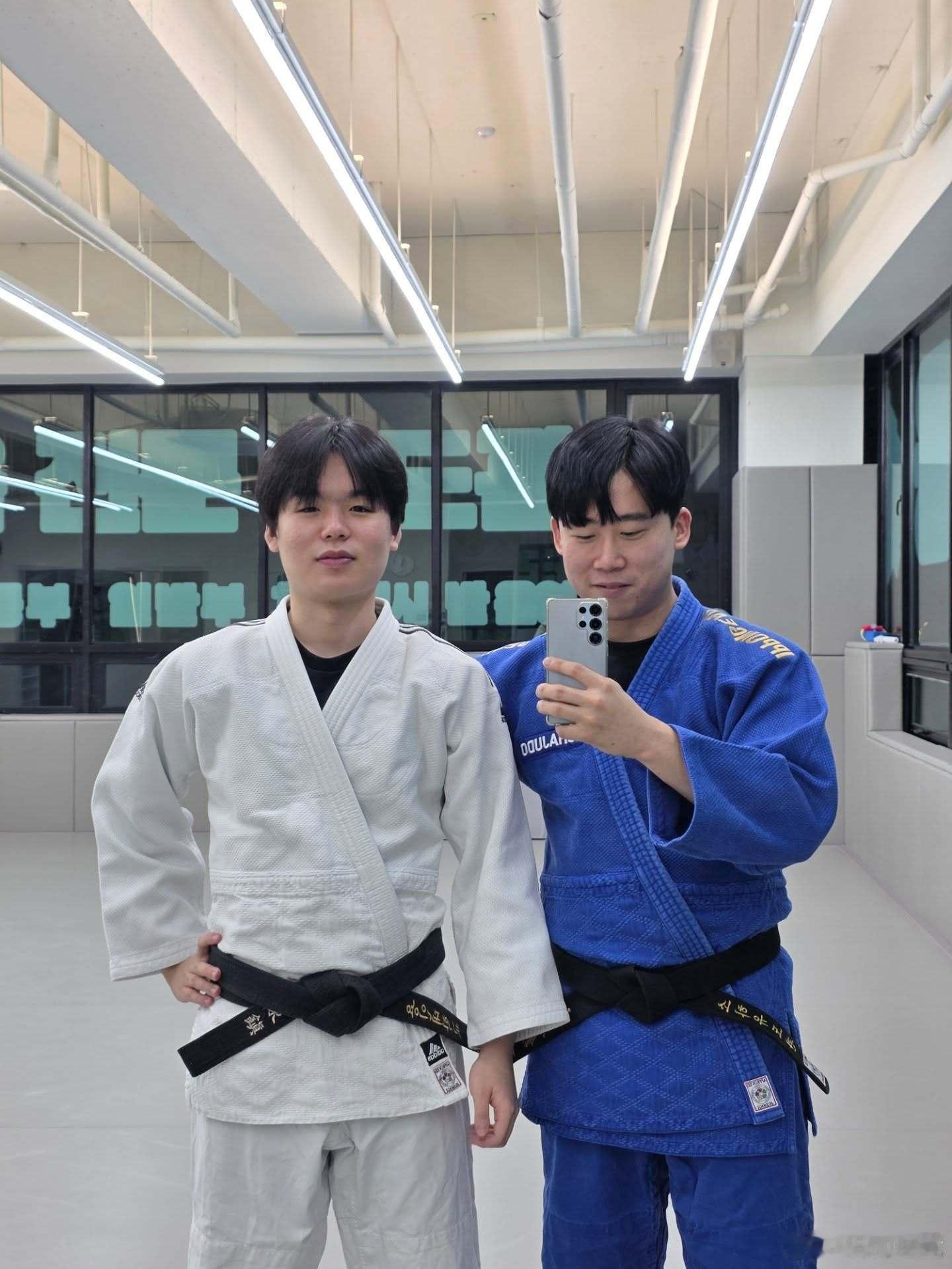 Smash在龙仁大学SoHa柔道馆展示柔道，身着白色道服将对手背负投摔倒。韩国电