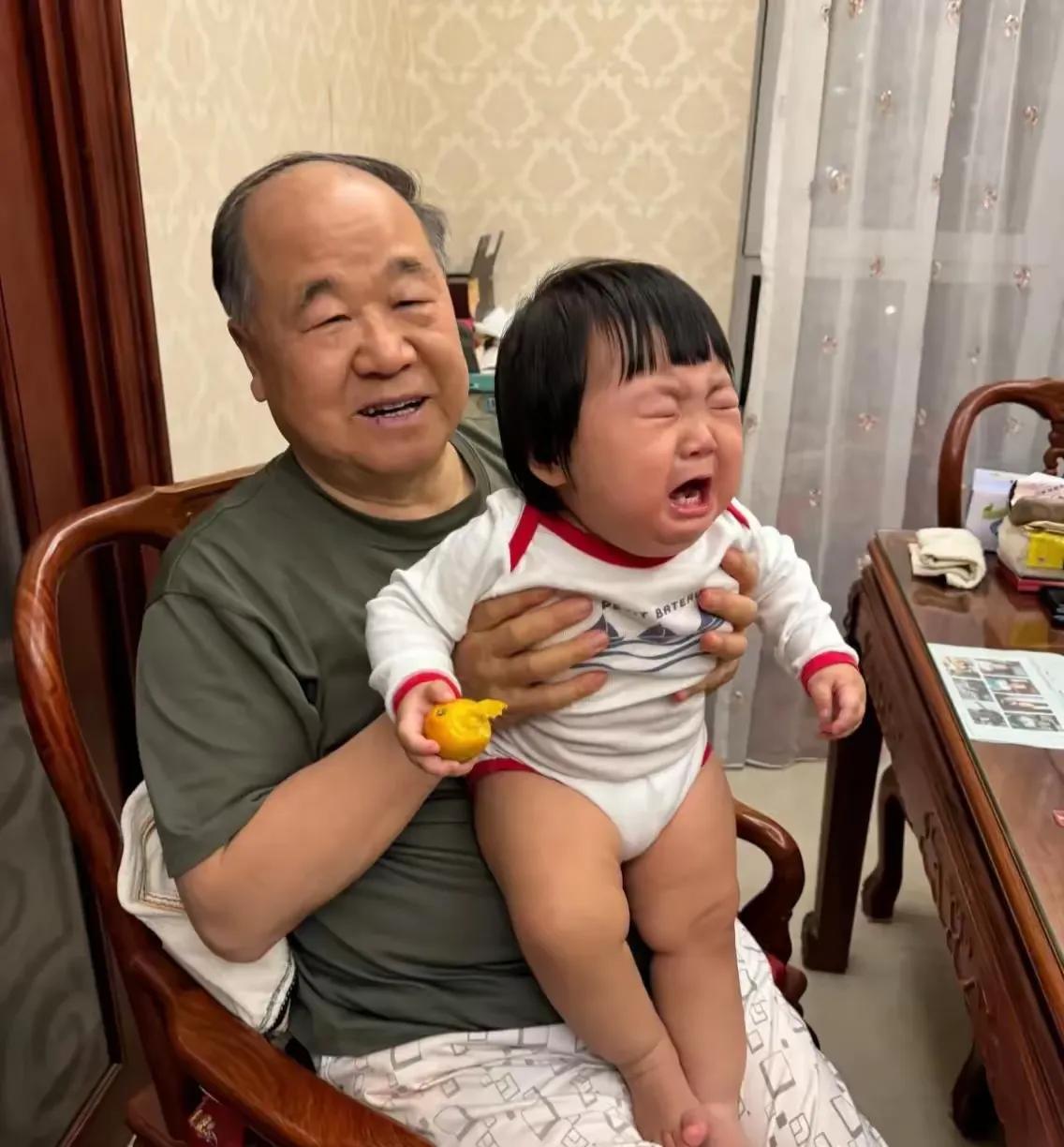 莫言带娃的照片算是火了，
网友说大作家也逃不过带娃的命运。

照片中莫言抱着小娃