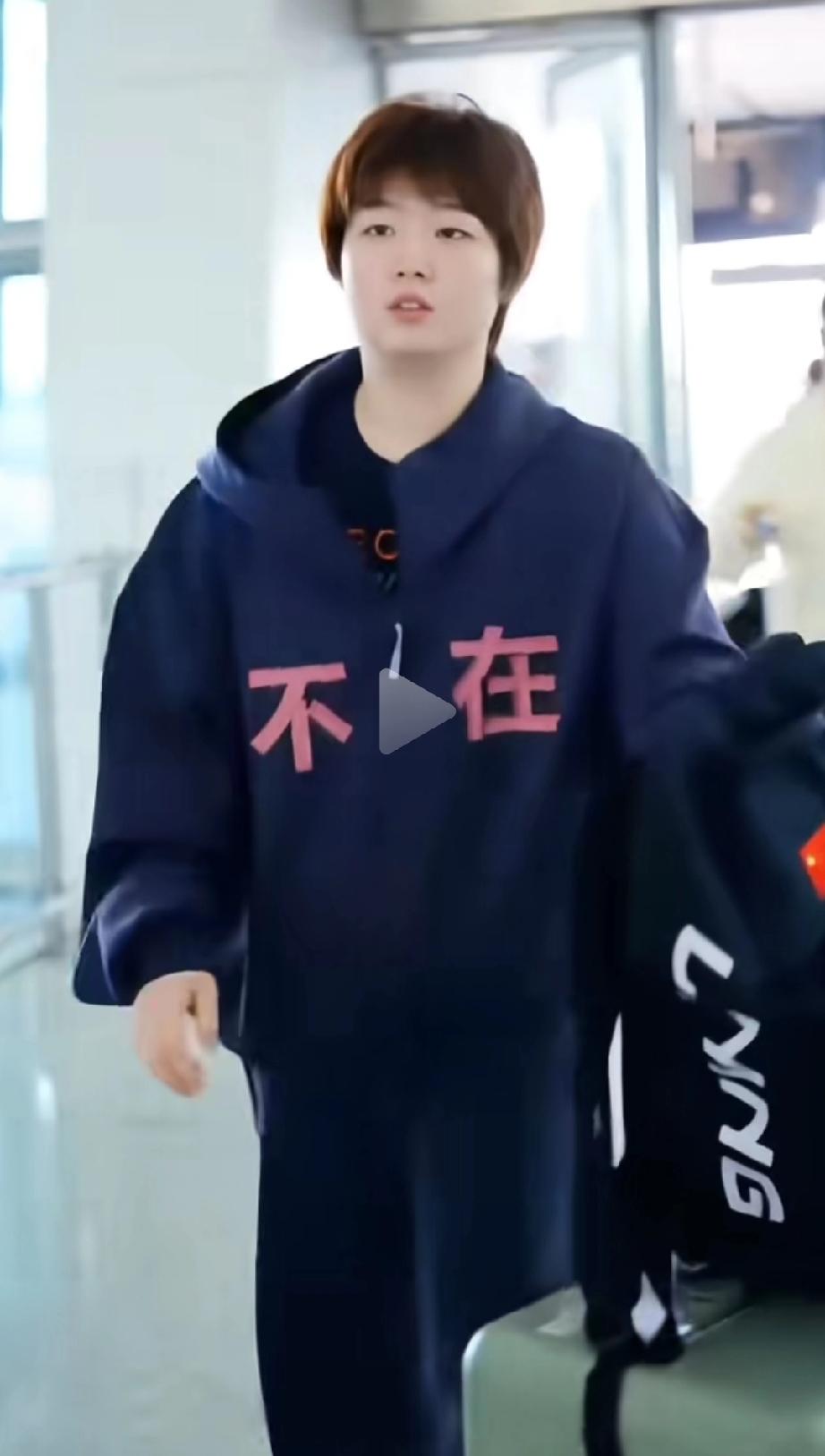 【蒯曼在机场，穿着的衣服上写着“不在”两个字】
国乒选手蒯曼出发前往澳门参加世界