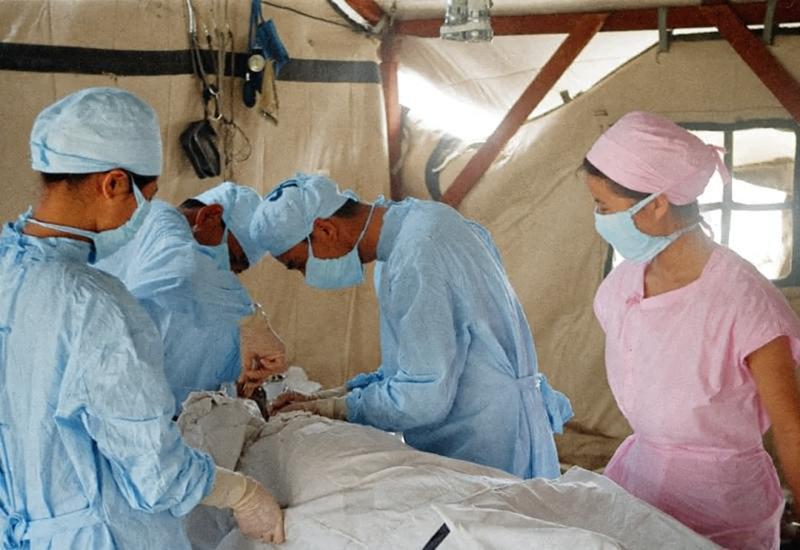 1976年，唐山地震期间，临时搭建的救灾帐篷内，顶上悬着简易的照明设备，几位解放