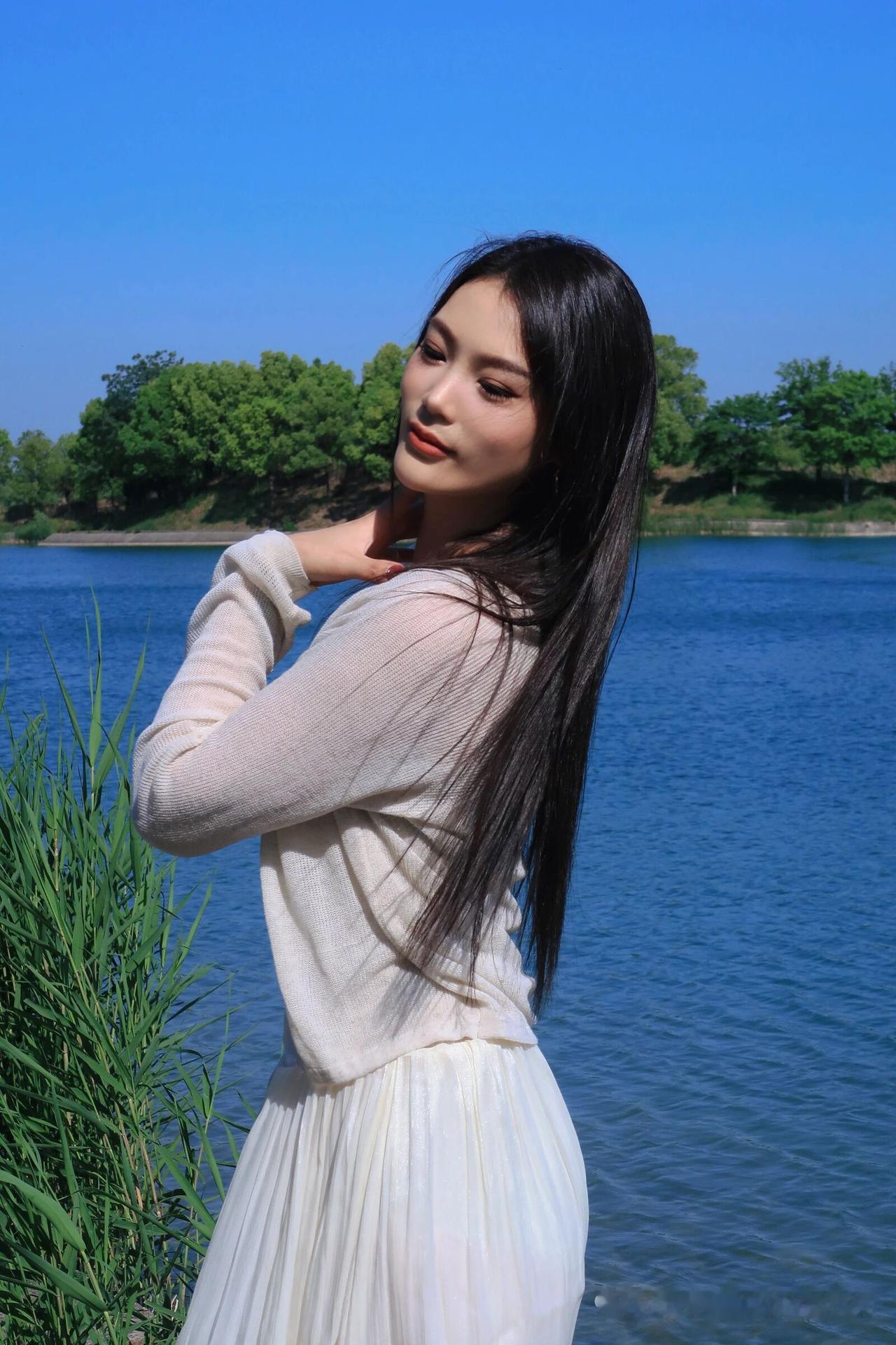 湖畔少女，白裙飘飘，微风轻拂发梢，岁月静好。