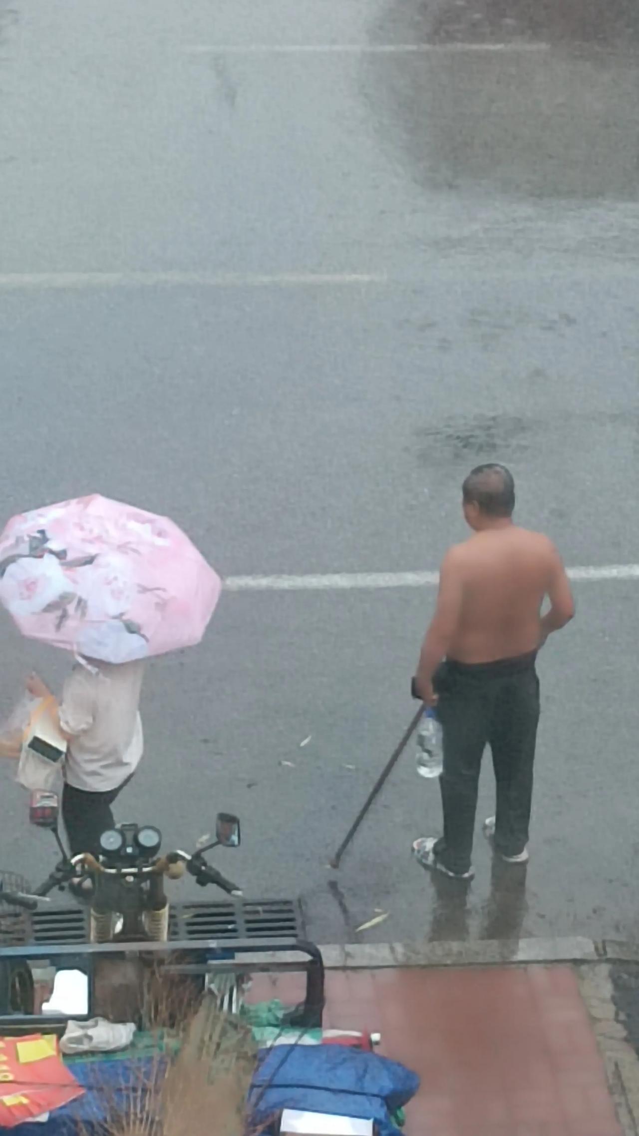 这是谁家老人？我的城市又在下大雨，我无意间瞥向窗外，一老人没穿上衣，伫立在大雨中