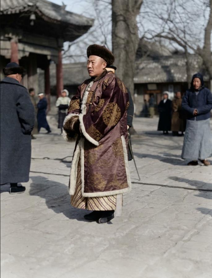 1919年，雍和宫“打鬼”法会，一位侧身站立、面容庄重的官员，目光凝望左侧。他头