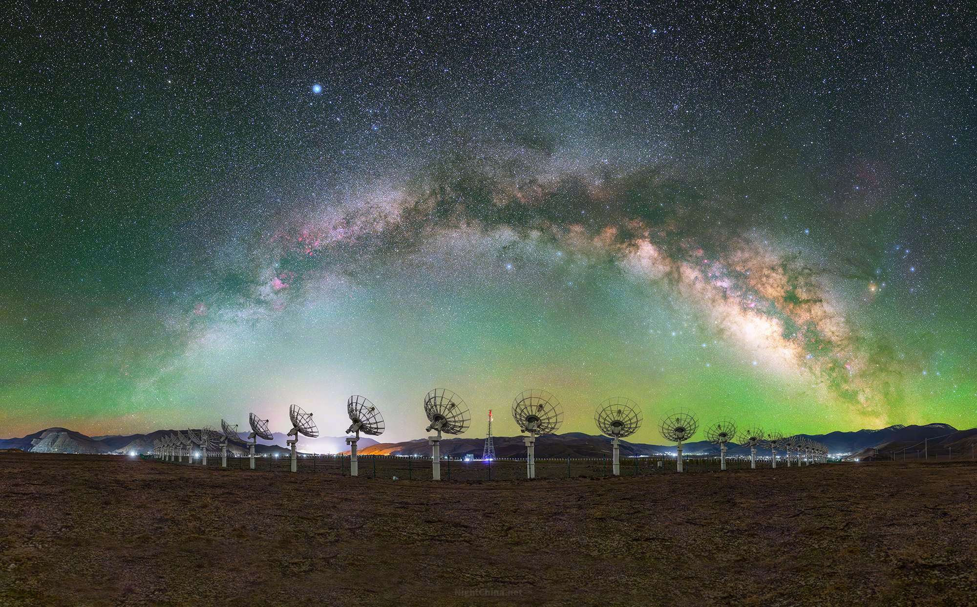稻城的夜，比任何地方都更靠近星河。淡绿的气辉漫过旷野，银河拱成一道弧，落脚在远山
