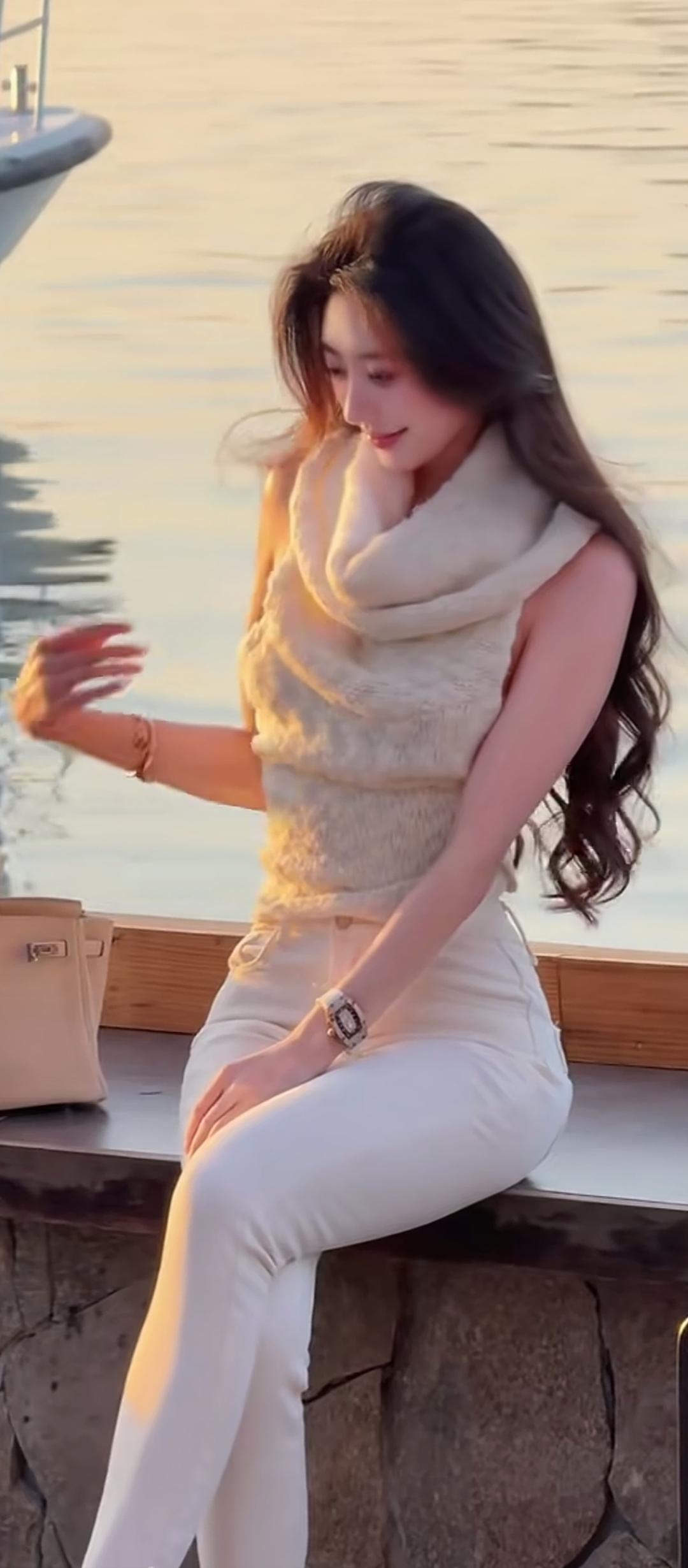 夕阳下的优雅时光，白色套装搭配米色围巾，尽显温柔与时尚。