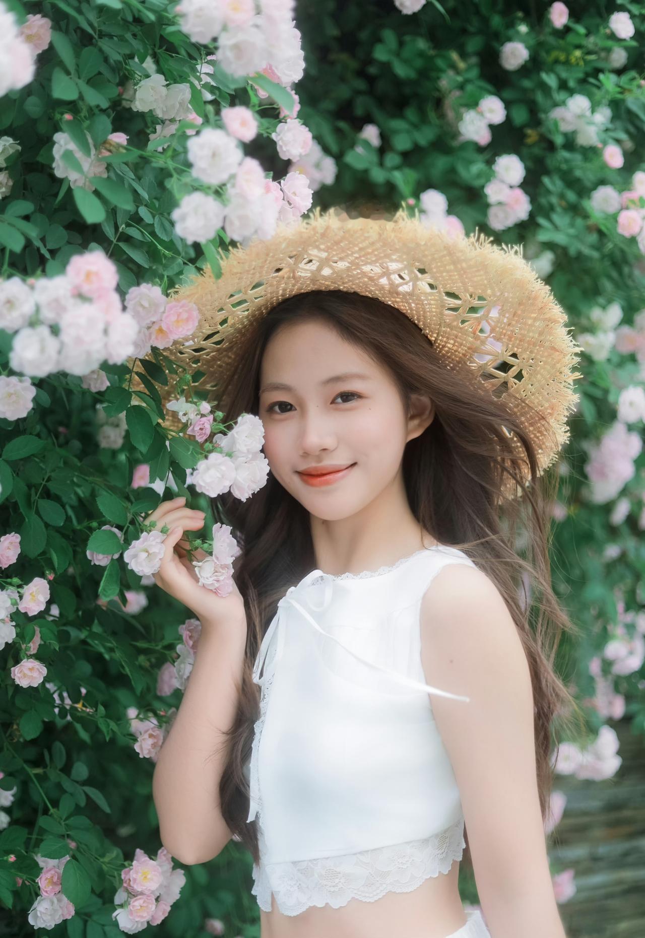一身洁白裙摆，一顶草帽轻晃，
在满墙温柔蔷薇花海里，
连呼吸都染上了清甜的春日气