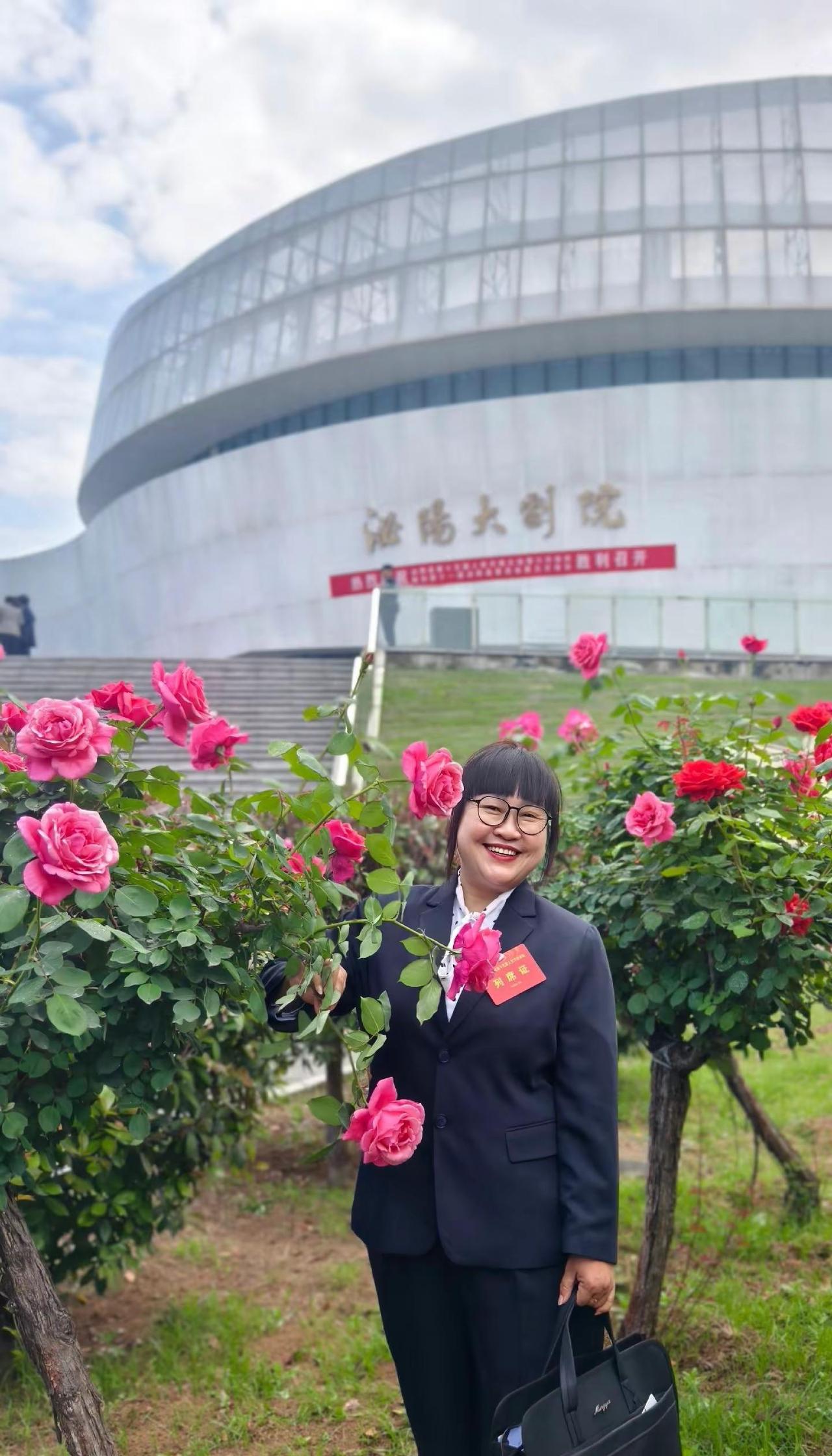 姹紫嫣红映三馆，盛装赴会意欣然。承民愿，赴新途，清气满怀花正鲜。花开恰似民心暖，