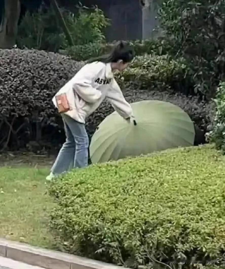好奇心让双方都很尴尬，我感觉这是AI制作的，两人穿着棉袄躲在绿色的伞下面