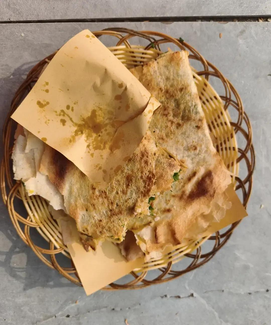 抖音博主晒8元菜煎饼说香到爆，我看完直接下单同款。
他蹲路边啃得满脸满足，镜头里