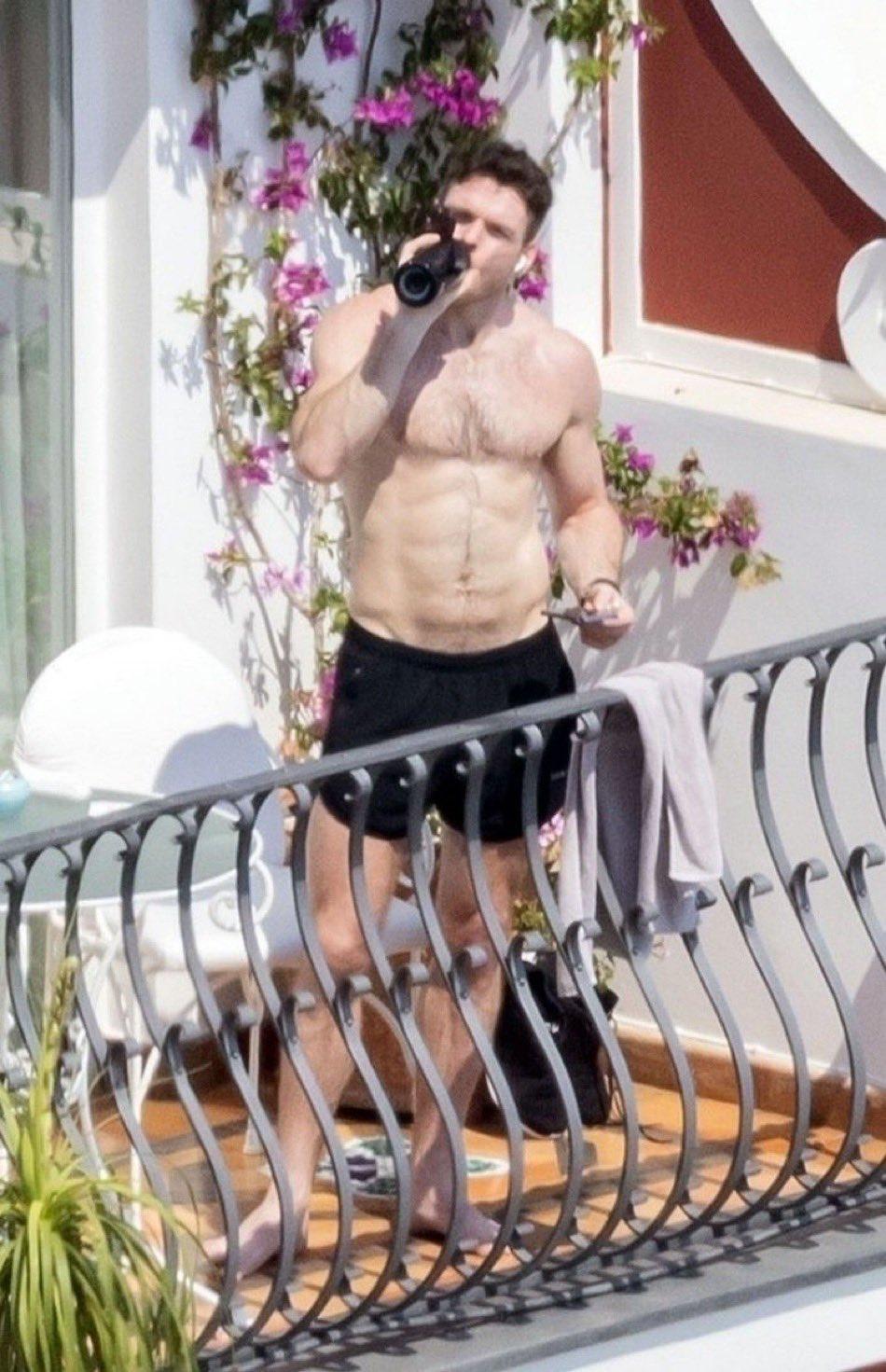 苏格兰男演员 Richard Madden（理察·麦登）在阳台喝水。