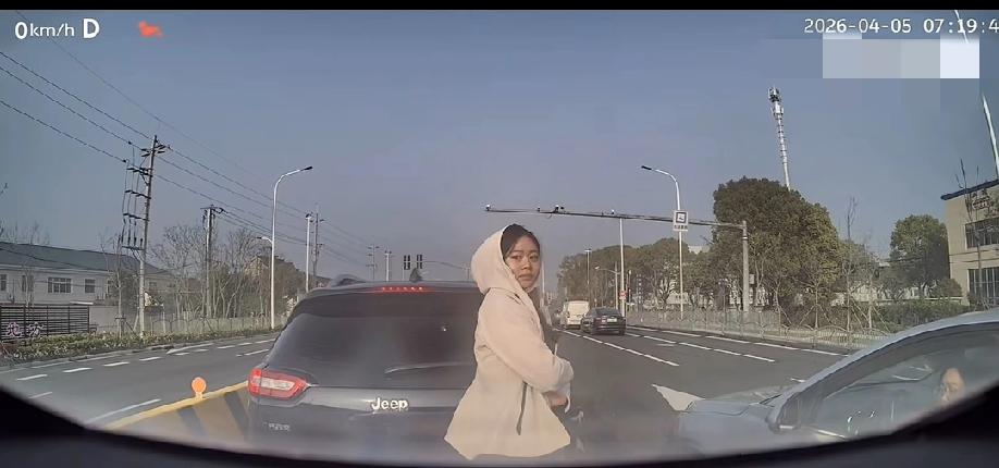 大家都在有序的排队通行，一银色车辆试图强行加塞未果。不料后座突然下来一名女子，径