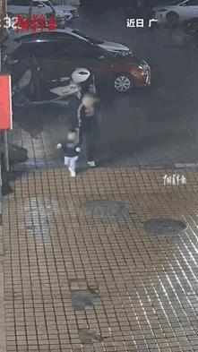 广东肇庆，雨天，一男子牵着孩子走在湿滑的路上，经过一个小斜坡时，男子没注意，一脚