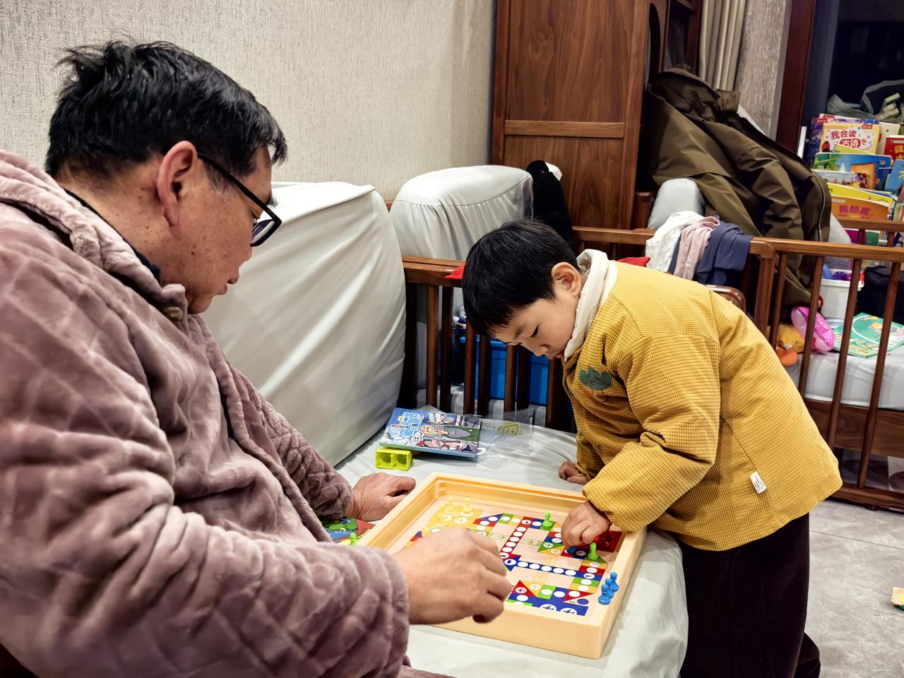 七绝·与圈圈下飞行棋
祖孙棋局兴戈兵，
掷子争先趣满枰。
笑看雏鹰频展翅，
佯愚
