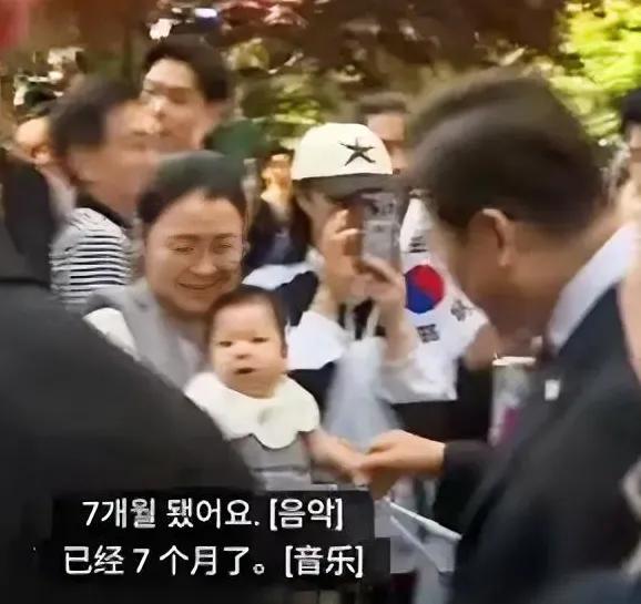 李在明真的很亲民，上班前先逗一下小孩子，问宝妈孩子的情况，多大啦，几个月了？他还