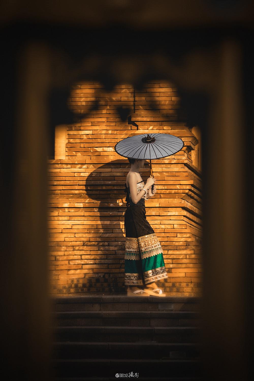 框中傣韵。透过石头灯台的空隙，镜头为这场傣风演绎框出了一方专属舞台。在...