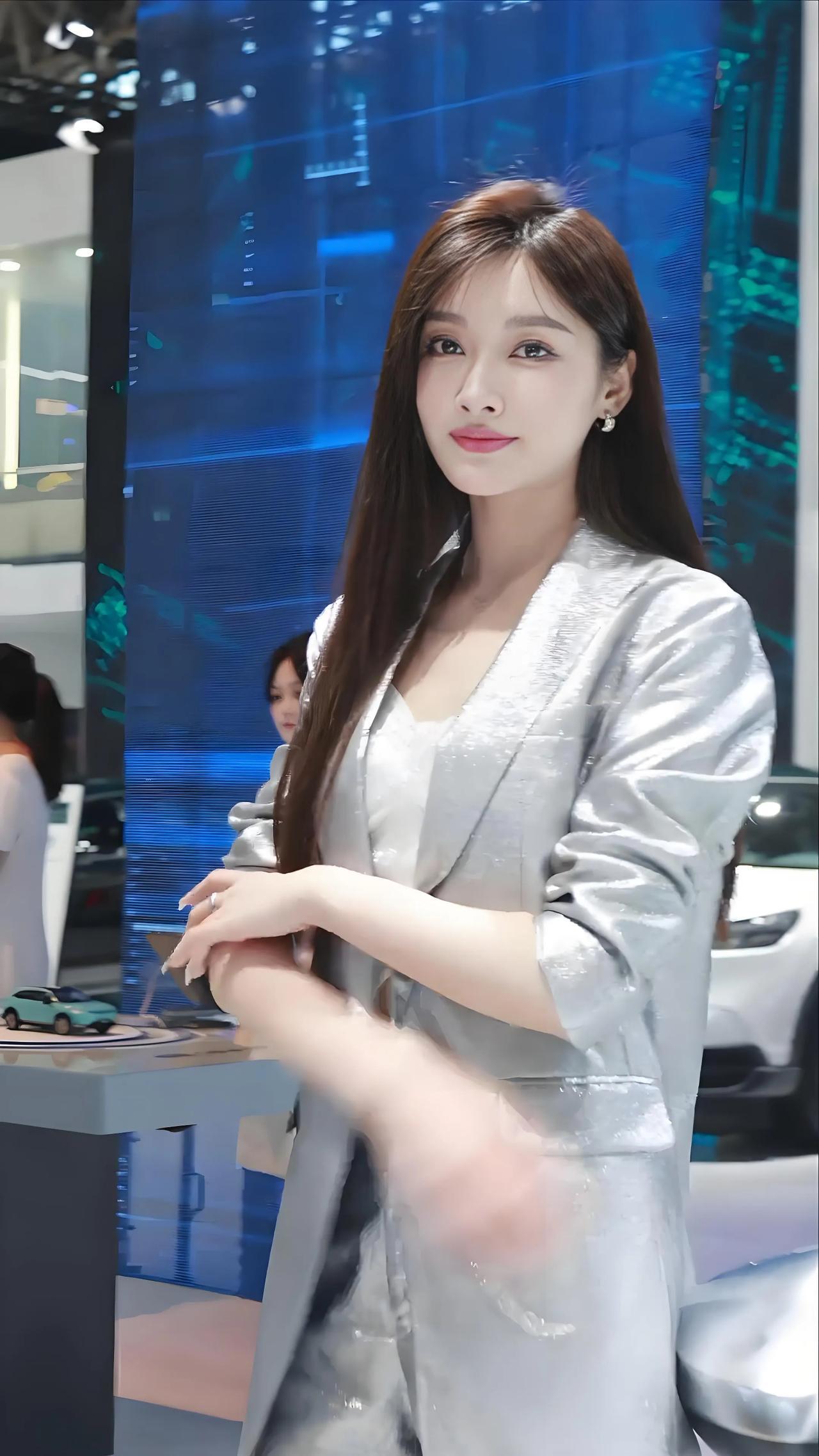 时尚展台上的优雅女性，闪耀的银色外套，科技感十足的背景，尽显现代都市风范。