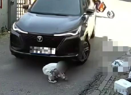 9月24日，辽宁盘锦一小男孩正在蹲地玩耍，一黑色轿车司机拐弯不慎碾压到男孩身上，