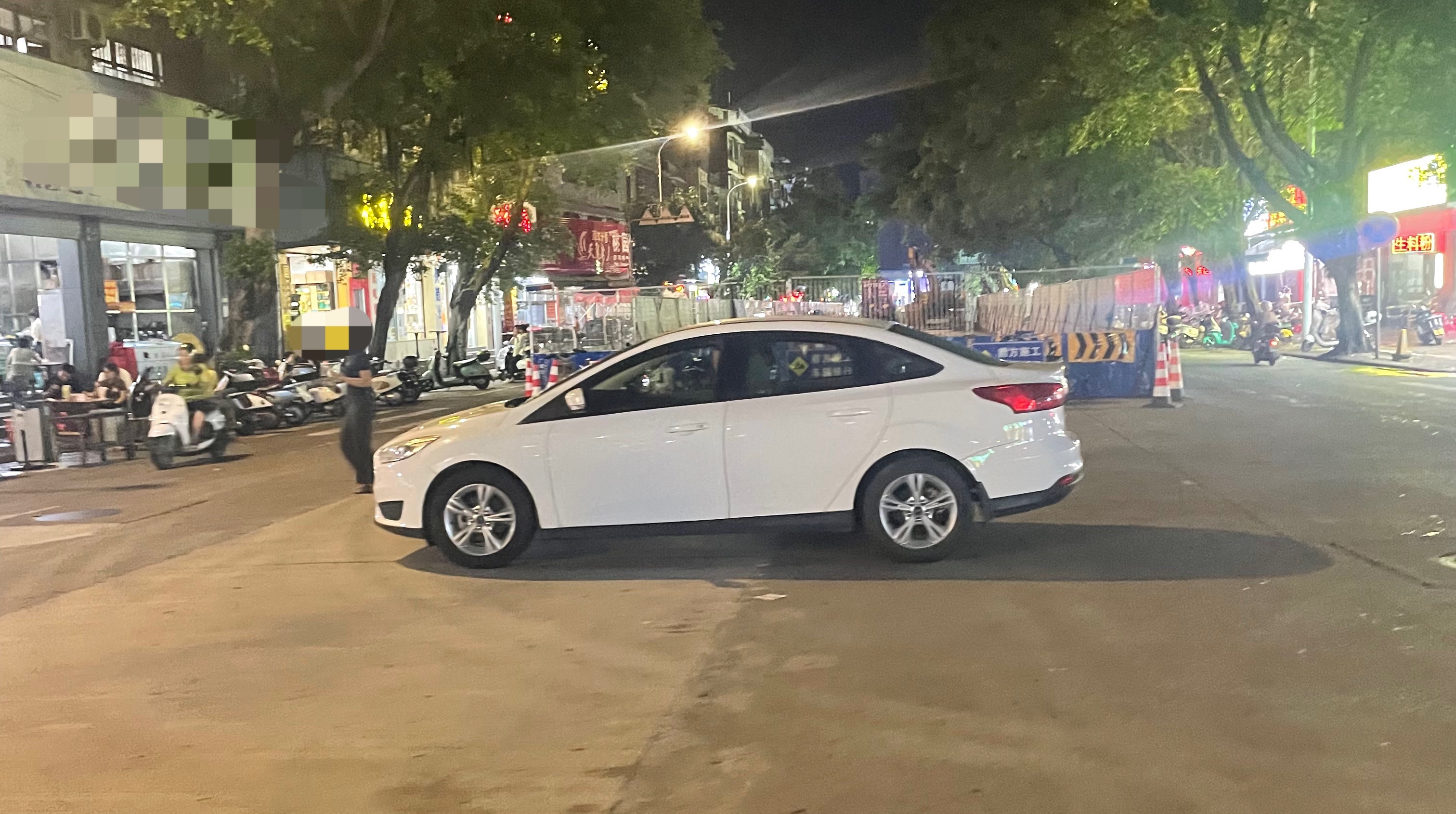 7月21日晚，玉林金玉路一十字路口变成了停车场 有一辆车牌号码为桂Ku5的白色小