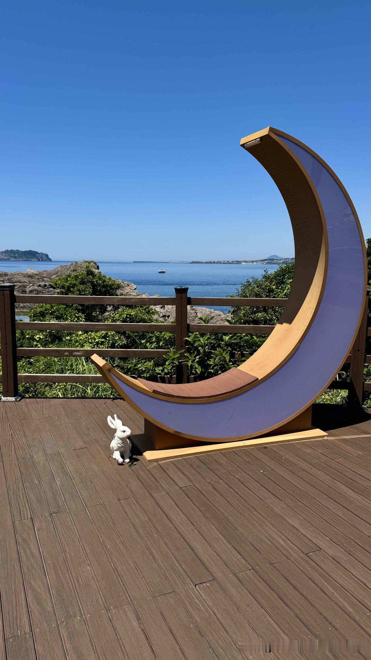 西归浦，西门环岛（公园），老远见一只小兔子躲在一月牙雕塑下，正歪着脑袋眺望着远处