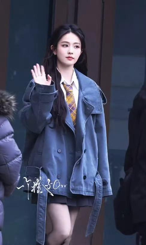 白鹿的穿搭风格偏学院风与休闲风结合，内搭是一件简约的白色衬衫，搭配带有黄紫格纹的