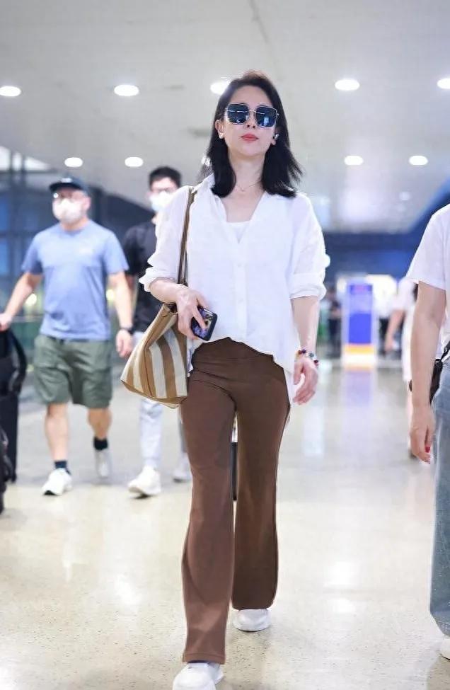 左小青这套机场穿搭太适合轻熟女生抄作业了！宽松白衬衫搭焦糖棕微喇西裤，小白鞋中和