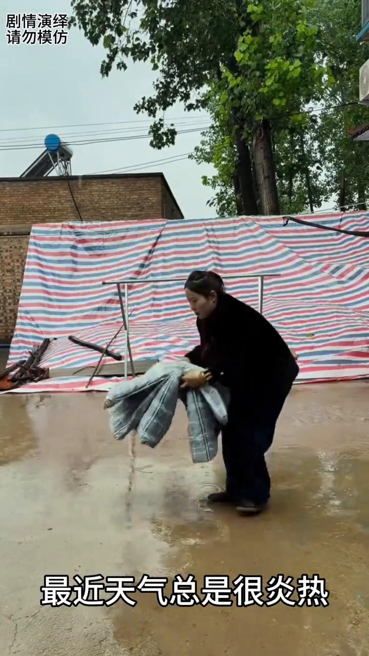 女子下雨天躺地上淋雨。
最近天气总是很炎热，谁知今天突然下起了小雨，于是女子赶紧