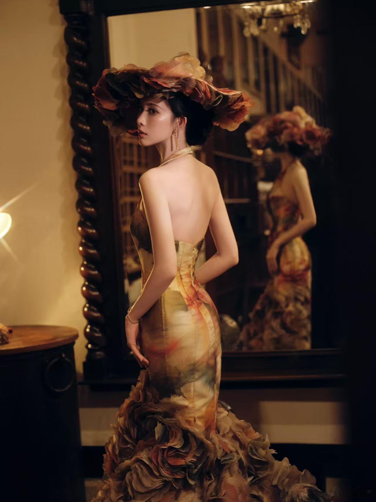 孟子义穿繁花晕染露背裙明艳复古，她穿露背装，戴夸张帽子，风情万种。