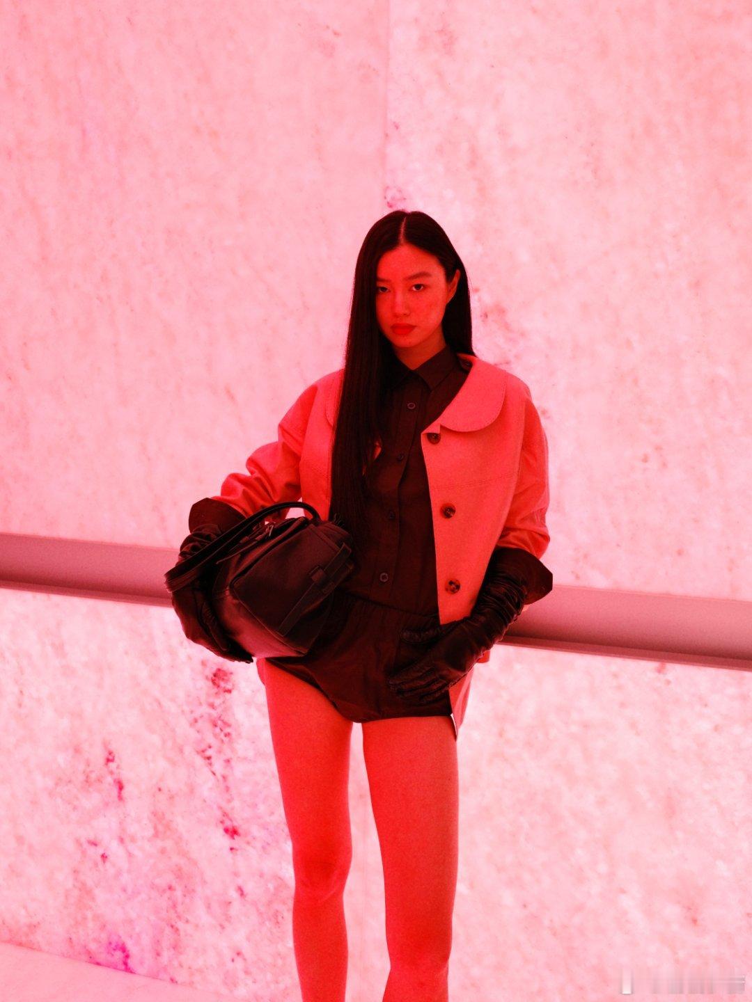 粉调外套撞色深棕衬衫，甜酷交织如冰与火共舞。长辫垂落似暗夜藤蔓，缠绕着皮革手套的