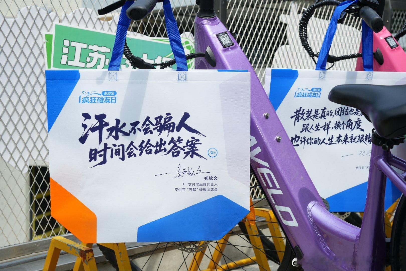 百店发支付宝助威袋为南京队加油 本来只是短暂路过，却被熙南里欢乐的游戏现场留住脚