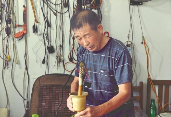 ​​
朱庆法在专注维修中。记者张晓曦 摄
清晨6时许，余姚阳明街道庙弄村，天色微