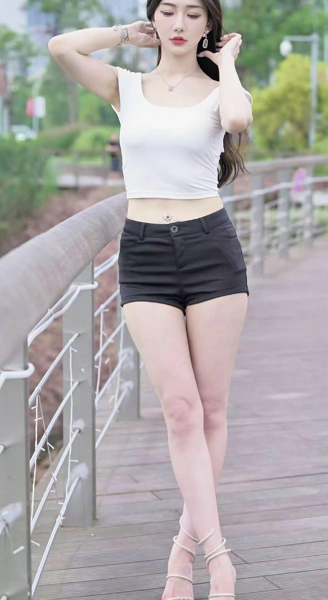 📸栏杆切割阳光的角度，恰好框住夏日的方程。露腰设计是对热力学的挑衅，而高跟鞋正