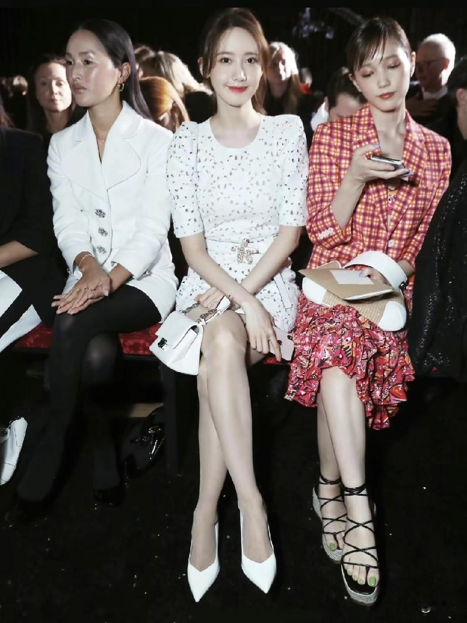 林允儿现身活动现场，一袭白色碎花连衣裙精致优雅，搭配同色系尖头高跟鞋与白色手提包