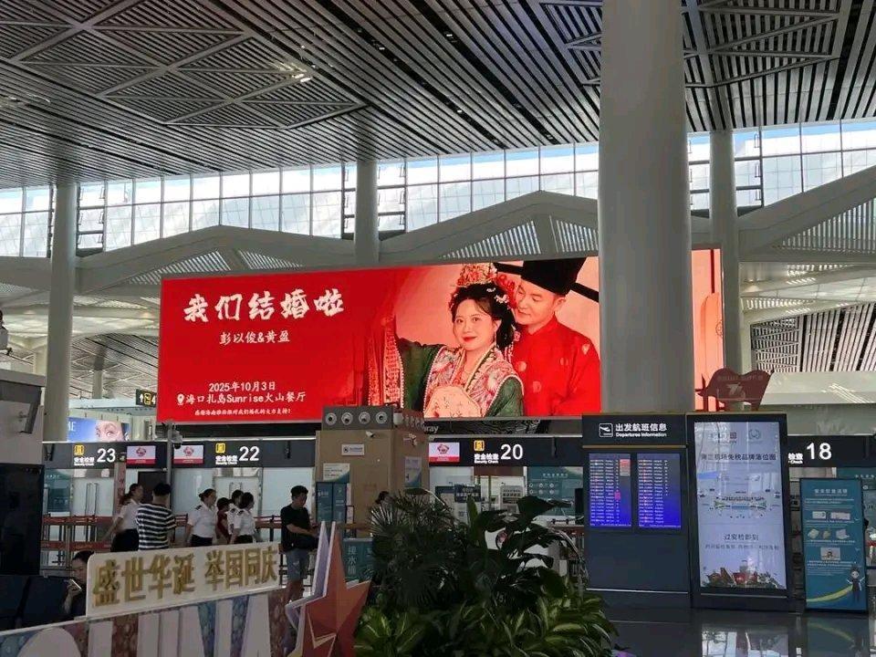 国庆期间，海口美兰机场88块屏幕连播8天一对新人的结婚请柬，这排面直接拉满，在社