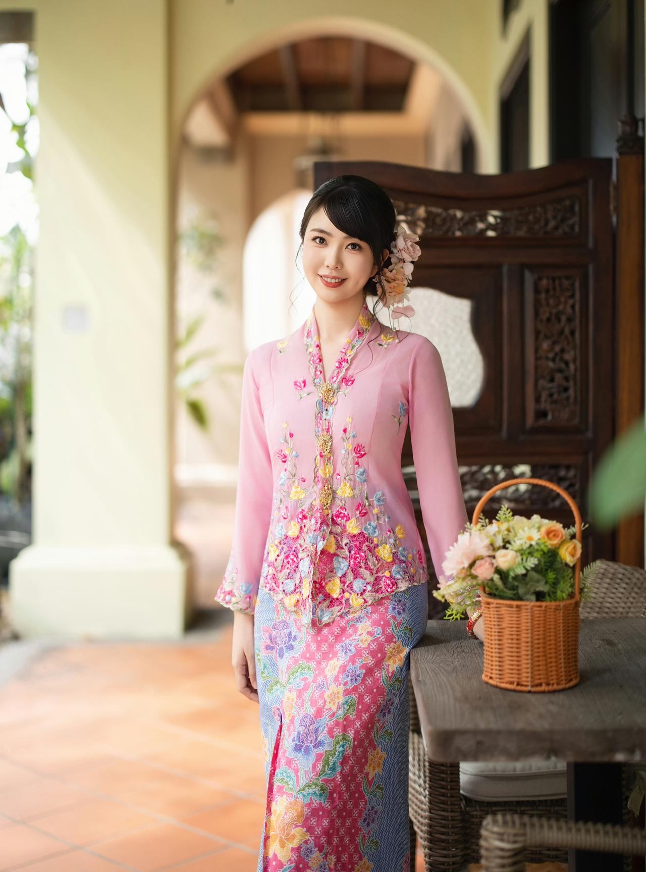 在南洋骑楼的光影里，粉色峇峇娘惹服的刺绣繁花，与古宅的雕花门窗相映成趣。

花篮