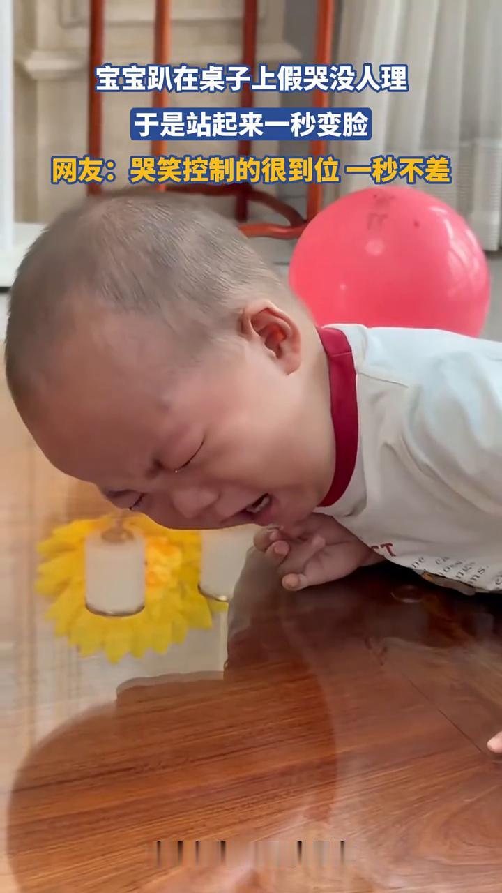 宝宝趴在桌子上假哭没人理，于是站起来一秒变脸。
网友：哭笑控制的很到位，一秒不差