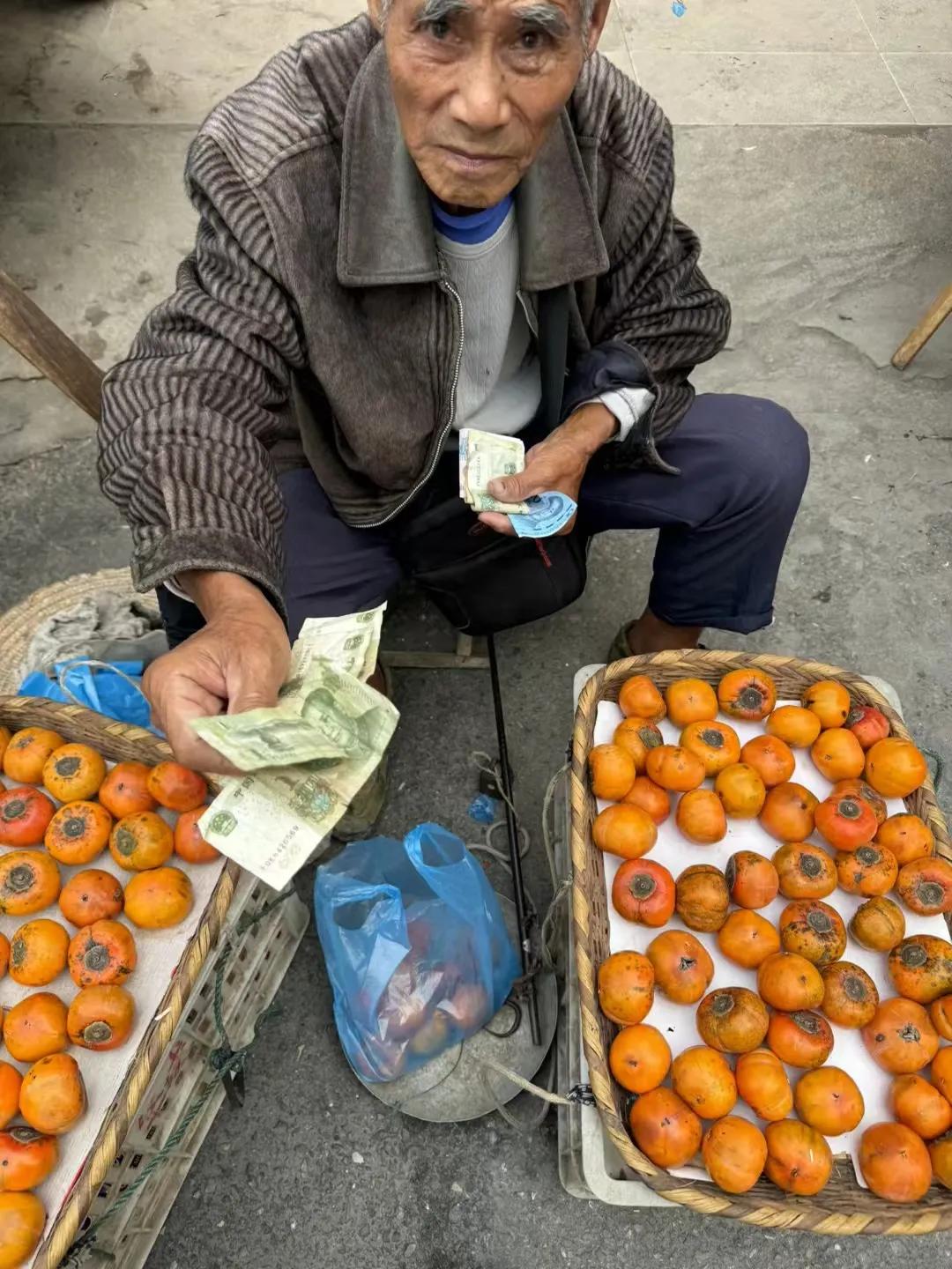 下班看见一老爷爷在卖柿子，我停下来看了看，准备走，他说：“今天一斤也没买！”我想