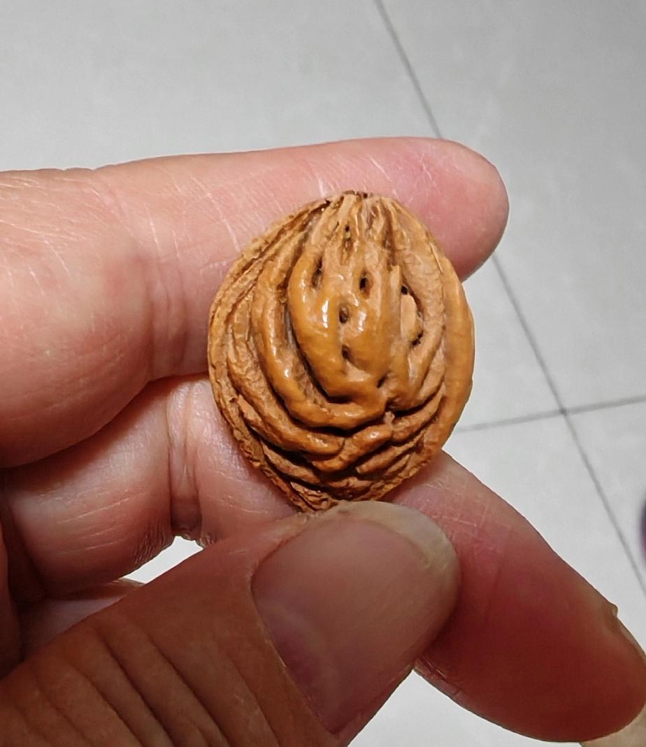 这枚桃枭真可爱，干净漂亮，最最主要的是，它上面有一张萌萌的鬼脸！
细细看看，这张