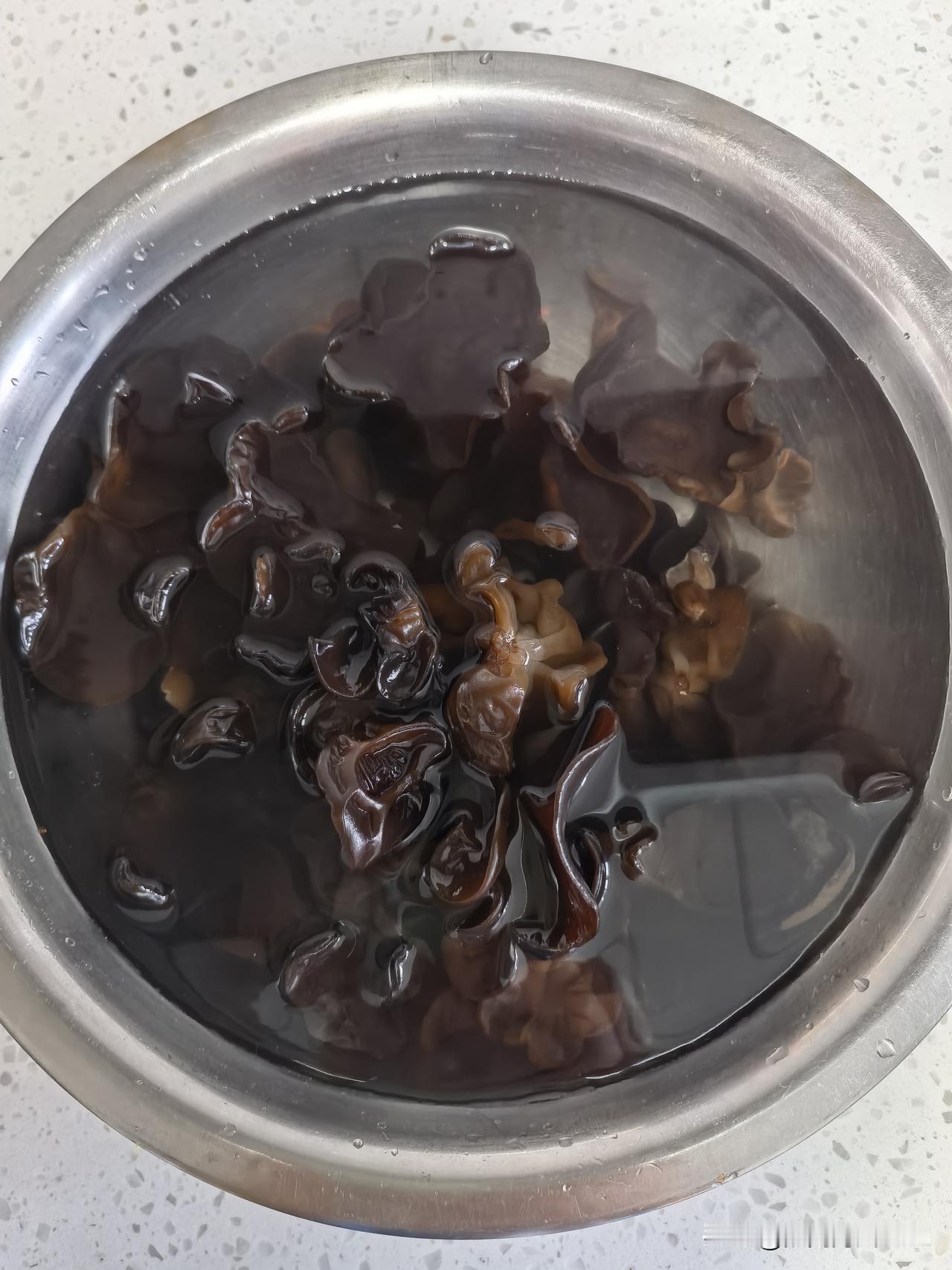 好长时间没吃木耳了，早起掏了出来，准备泡发点儿，中午圆葱炒木耳。

这袋木耳，还