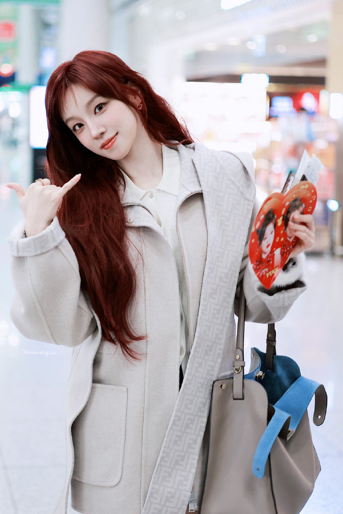 宋雨琦拿了自己的小福娃手幅 宋雨琦飞米兰，机场接过粉丝递来的手幅——上面印的是她