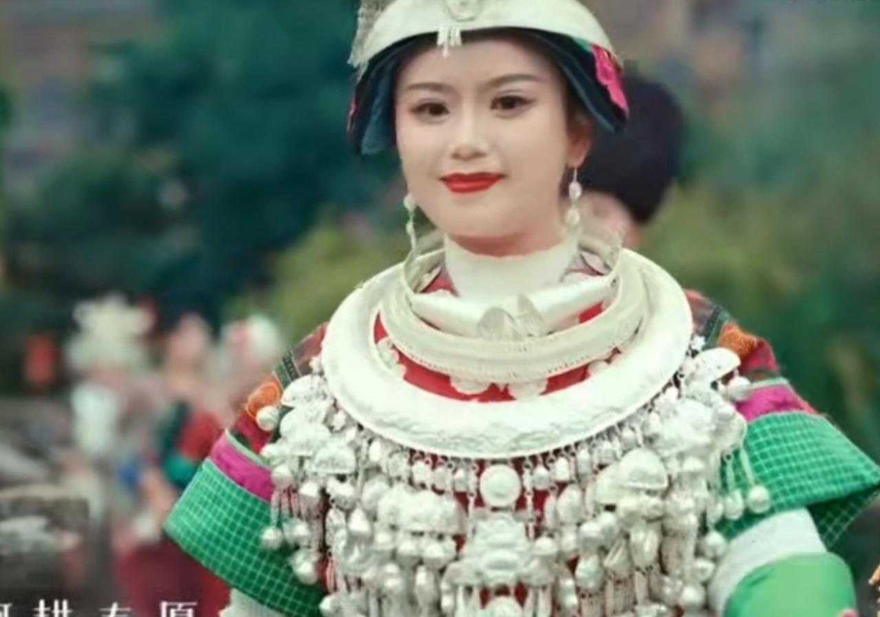 苗族姑娘身着缀满银饰的盛装，眉眼间尽显民族少女的灵动与秀美；碧绿湖水旁的木桥上，