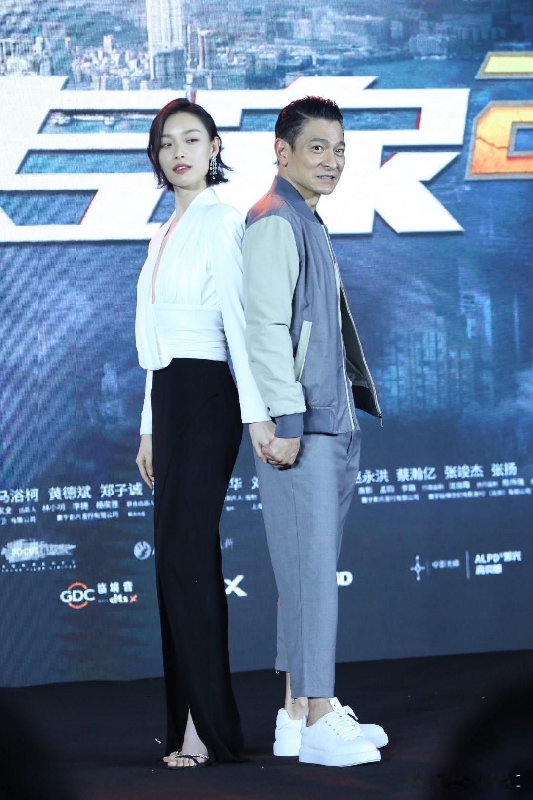 华仔与倪妮，背靠背牵手氛围感合照。