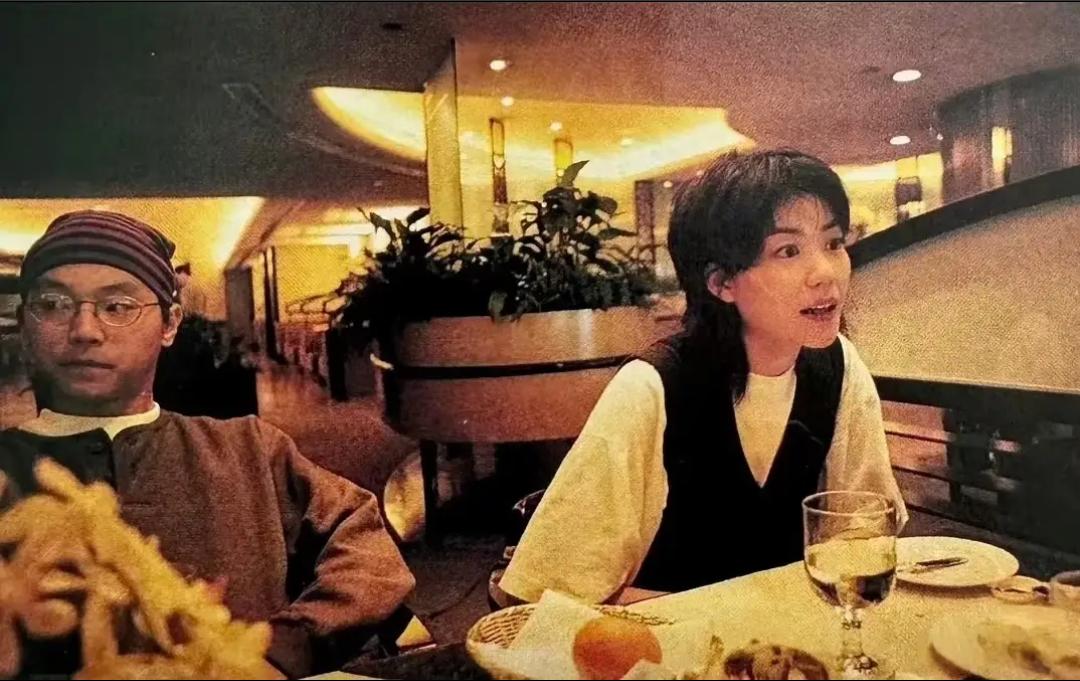 这是一张30年前窦唯与王菲在香港餐厅用餐照片，窦味戴的帽子很特别，年轻王菲真美丽