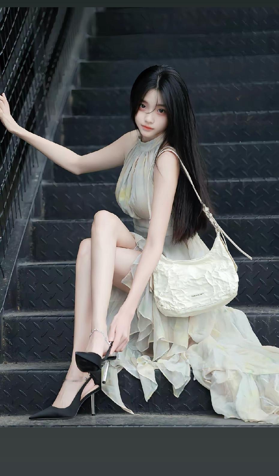 一个穿长裙的姑娘坐在台阶上。