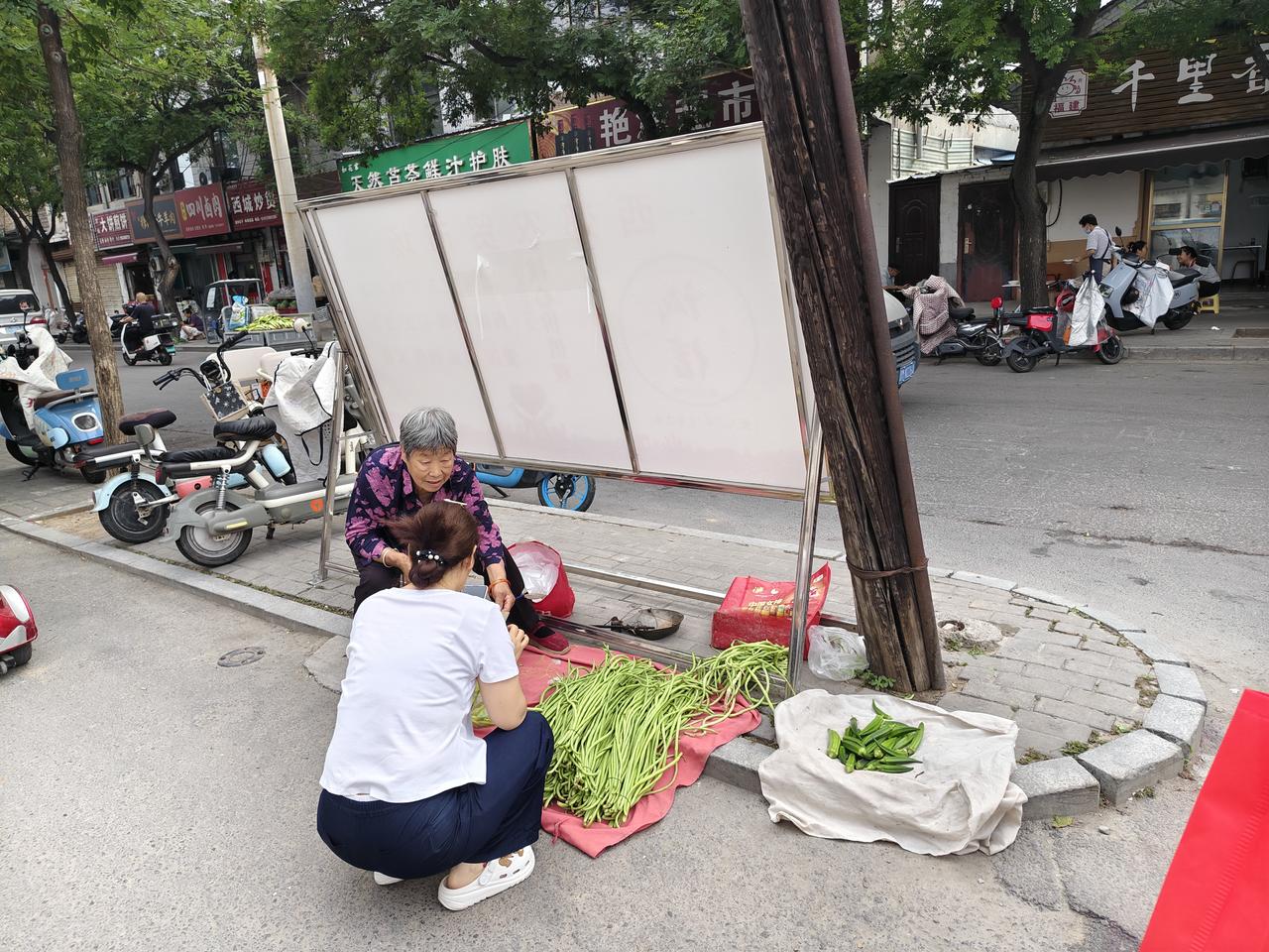 在运城盐湖西街早市口，这位大娘已近80岁，但她依然会不定期地来早市上卖自家种的菜