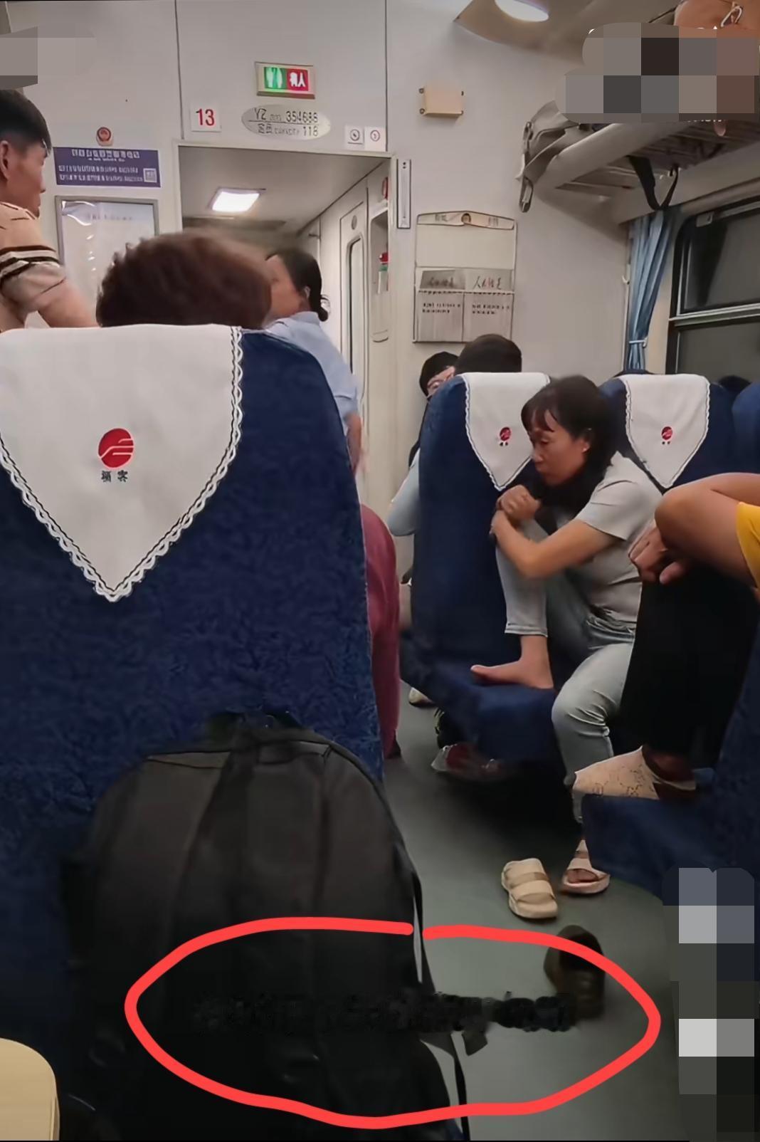 车厢内的一幕:晚上十点多，穿条纹上衣的男子在列车上外放刷视频，另一乘客让他小点声