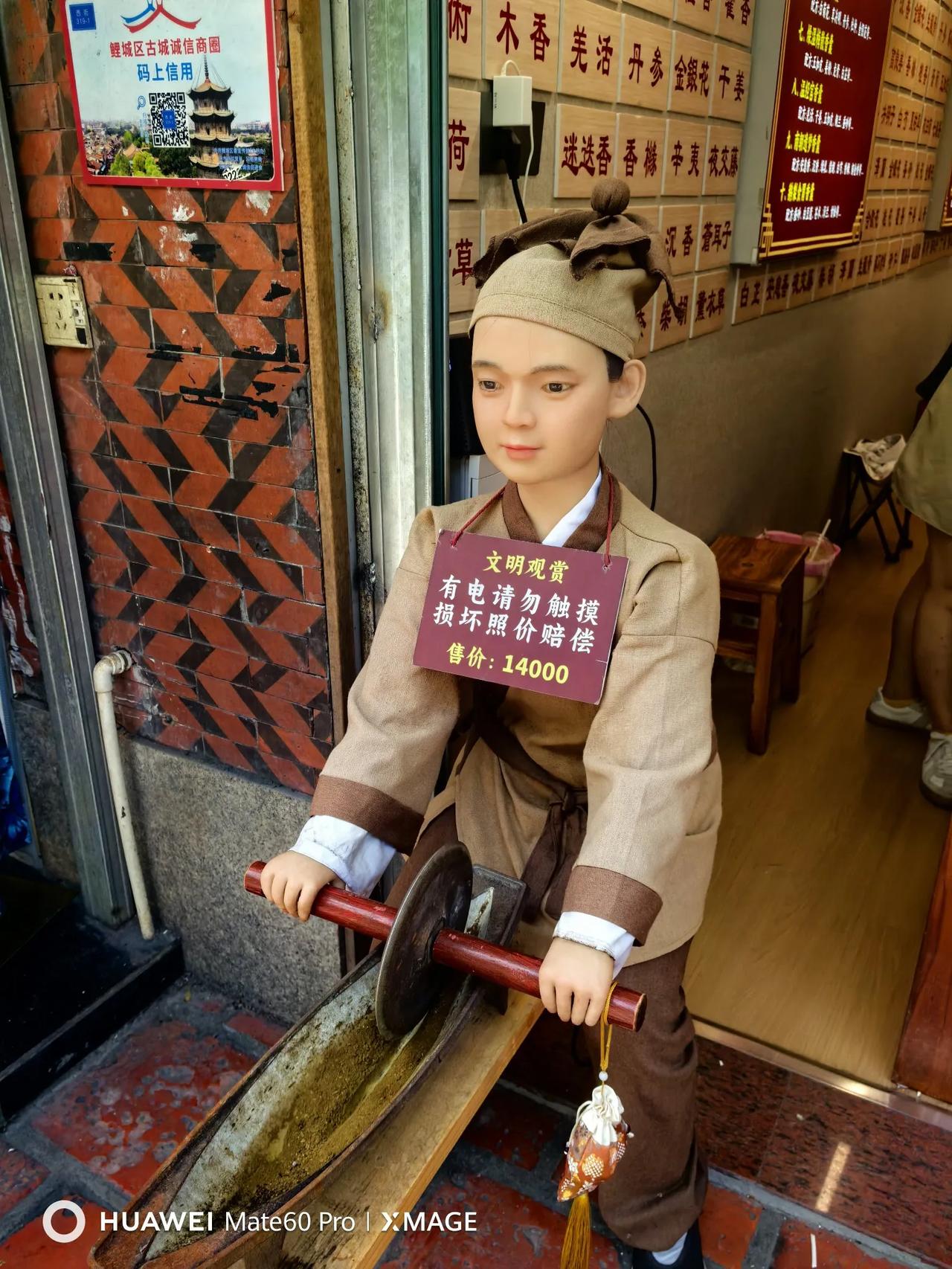 泉州西街的一个花囊小店前，有一个形象逼真的机器人小药童。一招一式甚是专业。不过只