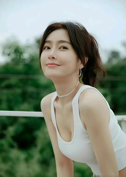 阳光明媚的午后，元气少女在绿意盎然的背景下，微笑着看向镜头，散发着青春活力。秦岚